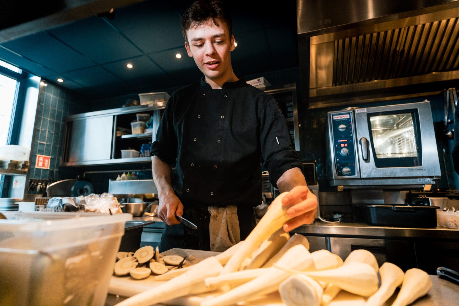 Mees pastinaak aan het schillen in de keuken bij Buurten in de Gaard